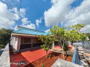 a house with a blue roof at ARMANI Villa Nagapattinam in Sikkil
