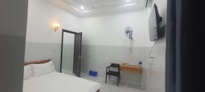 a bedroom with a bed and a chair and a television at Nhà Nghỉ Phi Yến in Phụng Hiệp +4 photos