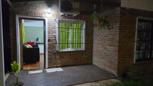 a room with a brick wall with a door and a kitchen at Departamentos Hernan in Apóstoles