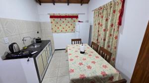 a small kitchen with a table and a refrigerator at Departamentos Hernan in Apóstoles
