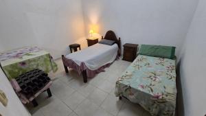 a small room with two beds and a table at Departamentos Hernan in Apóstoles