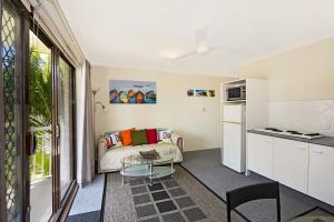 a living room with a couch and a table at Allamanda 37 in Long Jetty