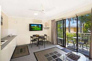 a kitchen and living room with a table and chairs at Allamanda 37 in Long Jetty