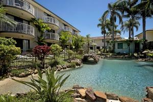 a swimming pool in front of a building at Allamanda 37 in Long Jetty