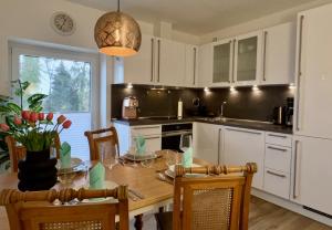 a kitchen with a wooden table with chairs and a dining room at INTERGO Apartments in Brackel