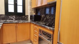 a kitchen with wooden cabinets and a stove top oven at Sleepin Girona in Girona