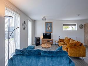 a living room with a blue couch and a table at Stylish Texel Escape with Spa in Den Burg