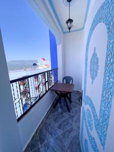 a balcony with a table and a view of the ocean at Casa Sharawy in Chefchaouen