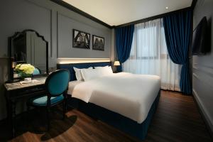 a bedroom with a large bed and a desk and a chair at Casa Dos Príncipes Hotel & Spa in Hanoi