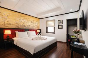 a bedroom with a large bed with a painting on the wall at Hanoi Sena Hotel & Travel in Hanoi