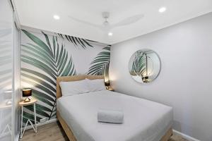 a small bedroom with a bed and a mirror at Ocean Pines Apartment 5 in The Entrance