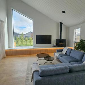 a living room with a couch and a flat screen tv at Mount Pisa View Stay - Barnd new holiday home in Cromwell
