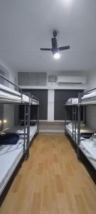 a room with three bunk beds and a ceiling fan at The Loft - Male Only in Chennai