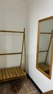 a mirror and a wooden bench in a room at Oasis Town in Carenero