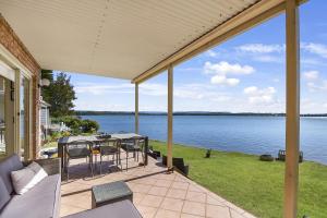 an outdoor patio with a view of the water at Bluewater at Mannering Park in Mannering Park