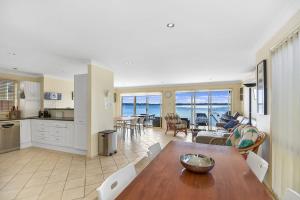 a kitchen and living room with a view of the ocean at Bluewater at Mannering Park in Mannering Park