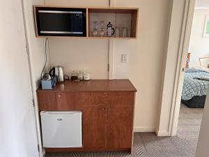 a small cabinet with a microwave and a television in a room at Cbay 2 bedroom Suite in Timaru