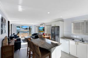 a kitchen and living room with a table and chairs at Ocean Pines Apartments 4 in The Entrance