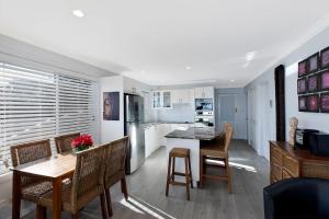 a kitchen and dining room with a table and chairs at Ocean Pines Apartments 4 in The Entrance +5 photos