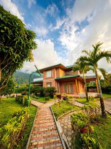 a house with a brick path in front of it at Suites Casa ColibrÍ in Mindo