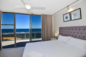 a bedroom with a bed and a view of the ocean at Beachfront on Werrina in Blue Bay  +12 photos