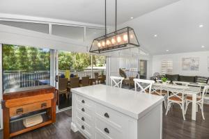 a kitchen and dining room with a table and chairs at Margaret's Hamptons Beach House in Hawks Nest