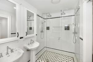 a white bathroom with a sink and a shower at Margaret's Hamptons Beach House in Hawks Nest +12 photos