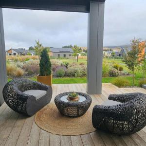 two chairs and a table on a patio with a view at Mount Pisa View Stay - Barnd new holiday home in Cromwell