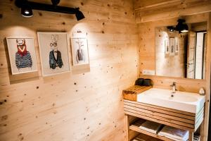 a bathroom with a white sink and wooden walls at Toksol Homes in Častonín +94 photos