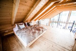 a large bed in a wooden room with a large window at Toksol Homes in Častonín