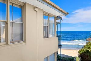a house with windows looking out at the ocean at Golden Sands Apartment 10 in The Entrance