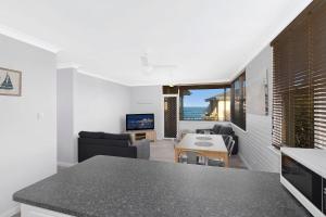 a kitchen and living room with a view of the ocean at Golden Sands Apartment 10 in The Entrance