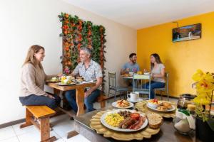 a group of people sitting at a table with food at Back Packer in Ibarra