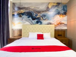 a bedroom with a white bed with a red blanket at RedDoorz Plus at edOtel Malang in Betek