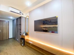 a living room with a flat screen tv on a wall at RedDoorz Plus at edOtel Malang in Betek
