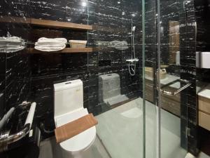 a bathroom with a toilet and a glass shower at RedDoorz Plus at edOtel Malang in Betek +89 photos