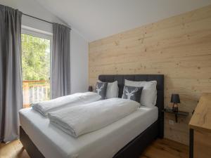 a bed with white sheets and pillows in a bedroom at Chalet in Turracher Höhe with Ski Slope Access in Turracher Hohe