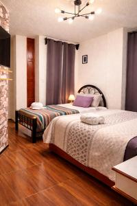 two beds in a room with wooden floors at Hotel Los Diamantes Orizaba in Orizaba