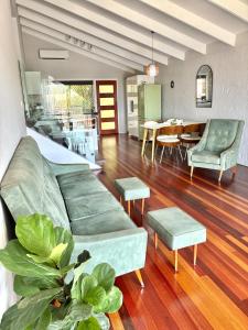 a living room with a couch and a table at The Sage Sea Shack in Caloundra +21 photos