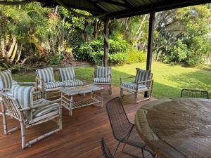 a group of chairs and a table on a deck at The Sage Sea Shack in Caloundra