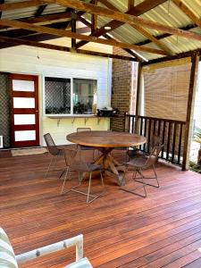 a patio with a table and chairs on a deck at The Sage Sea Shack in Caloundra