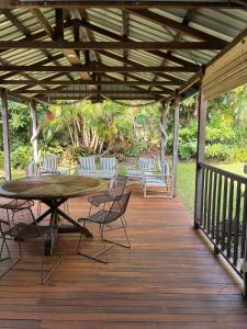 a wooden deck with a table and chairs on it at The Sage Sea Shack in Caloundra