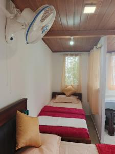 ein Schlafzimmer mit zwei Betten und einem Ventilator in der Unterkunft Blackcherry Munnar in Munnar