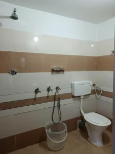 ein Badezimmer mit Toilette und Eimer in der Unterkunft Blackcherry Munnar in Munnar