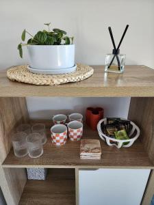 a shelf with a plant and bowls on it at Ocean View Oasis in Cannonvale