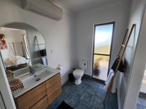 a bathroom with a sink and a toilet and a mirror at Ocean View Oasis in Cannonvale +2 photos