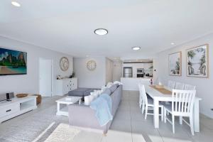 a dining room and living room with a table and chairs at Coast Apartments 19 Roof Top Pool in The Entrance