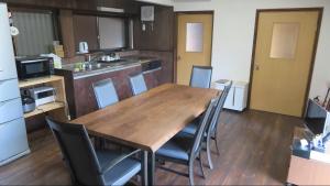 a kitchen with a long wooden table and chairs at 尾上邸 日本遺産の一棟貸し 離島の宿 in Marugame