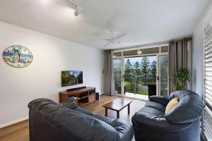 a living room with two leather couches and a television at Regency Court 4 in The Entrance