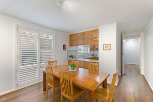 a kitchen and dining room with a wooden table and chairs at Regency Court 4 in The Entrance +3 photos